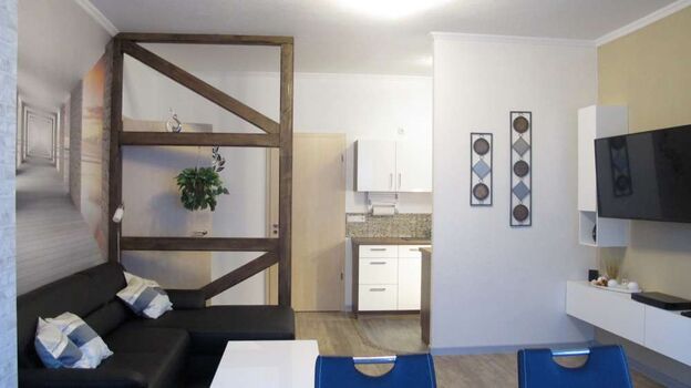 Wohnzimmer mit halboffener Küche