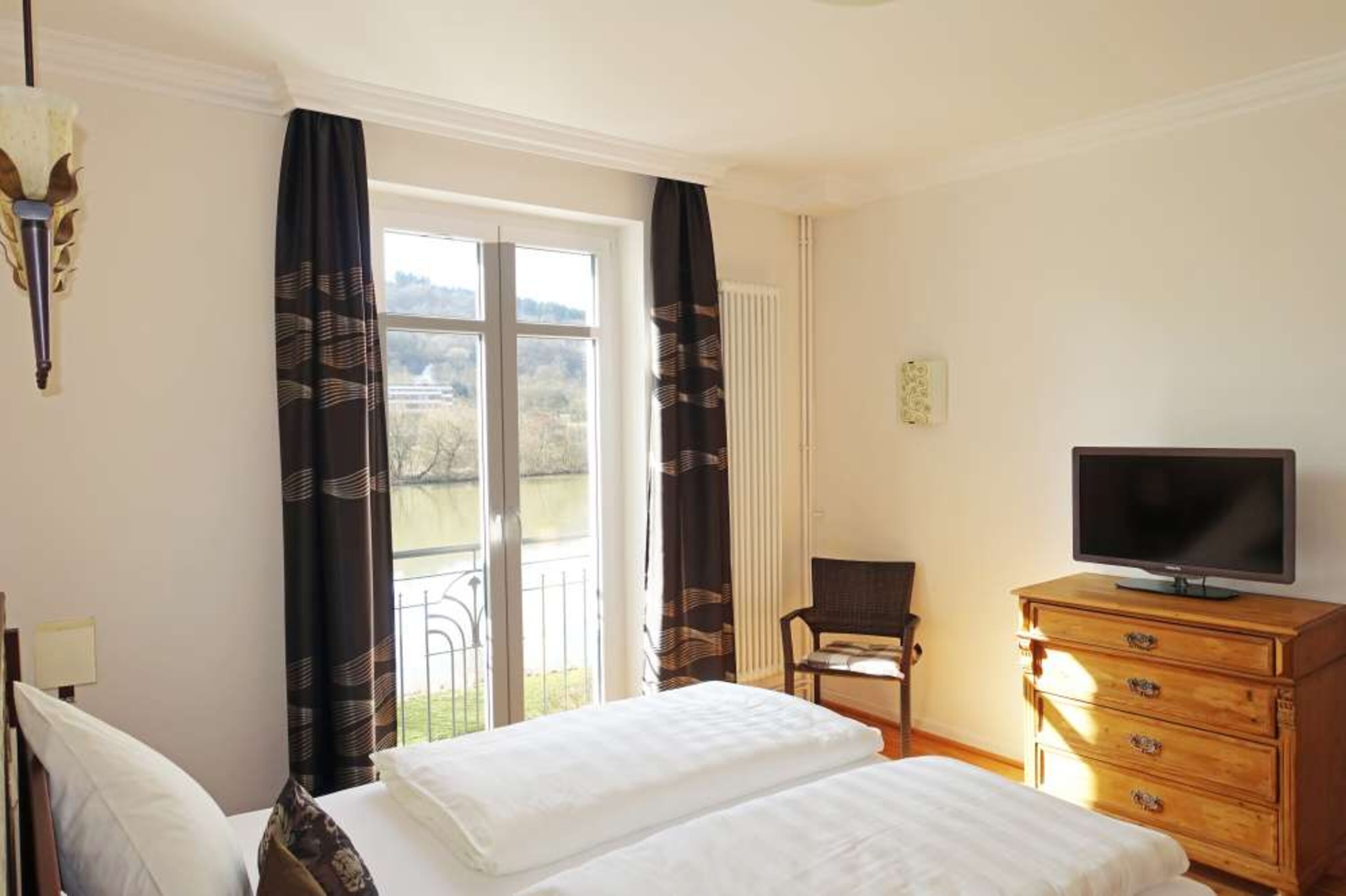 Schlafzimmer mit Flachbild-TV und Blick aufs Wasser