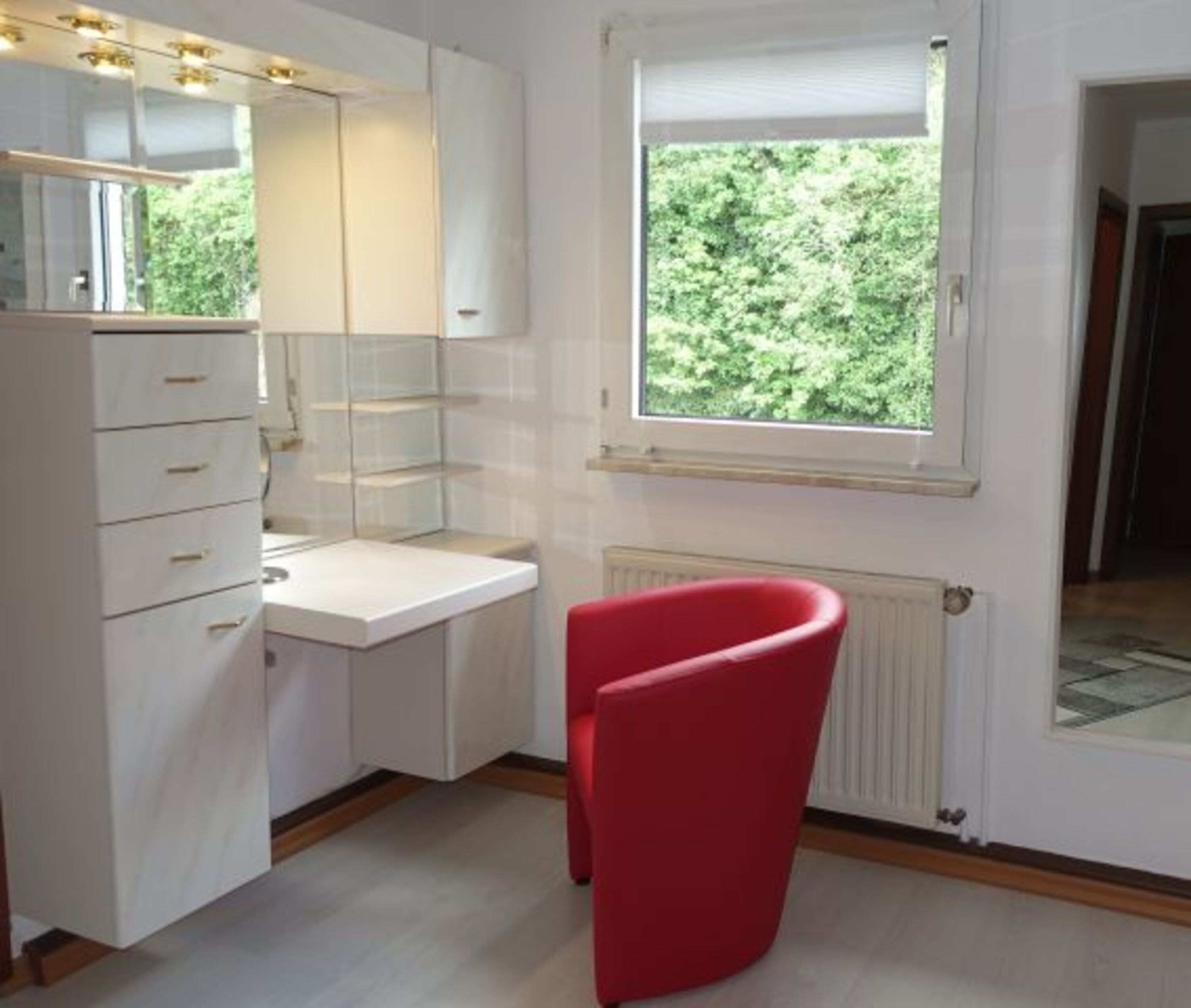 Ankleidezimmer mit Frisier- und Schminktisch mit Zugang ins Bad