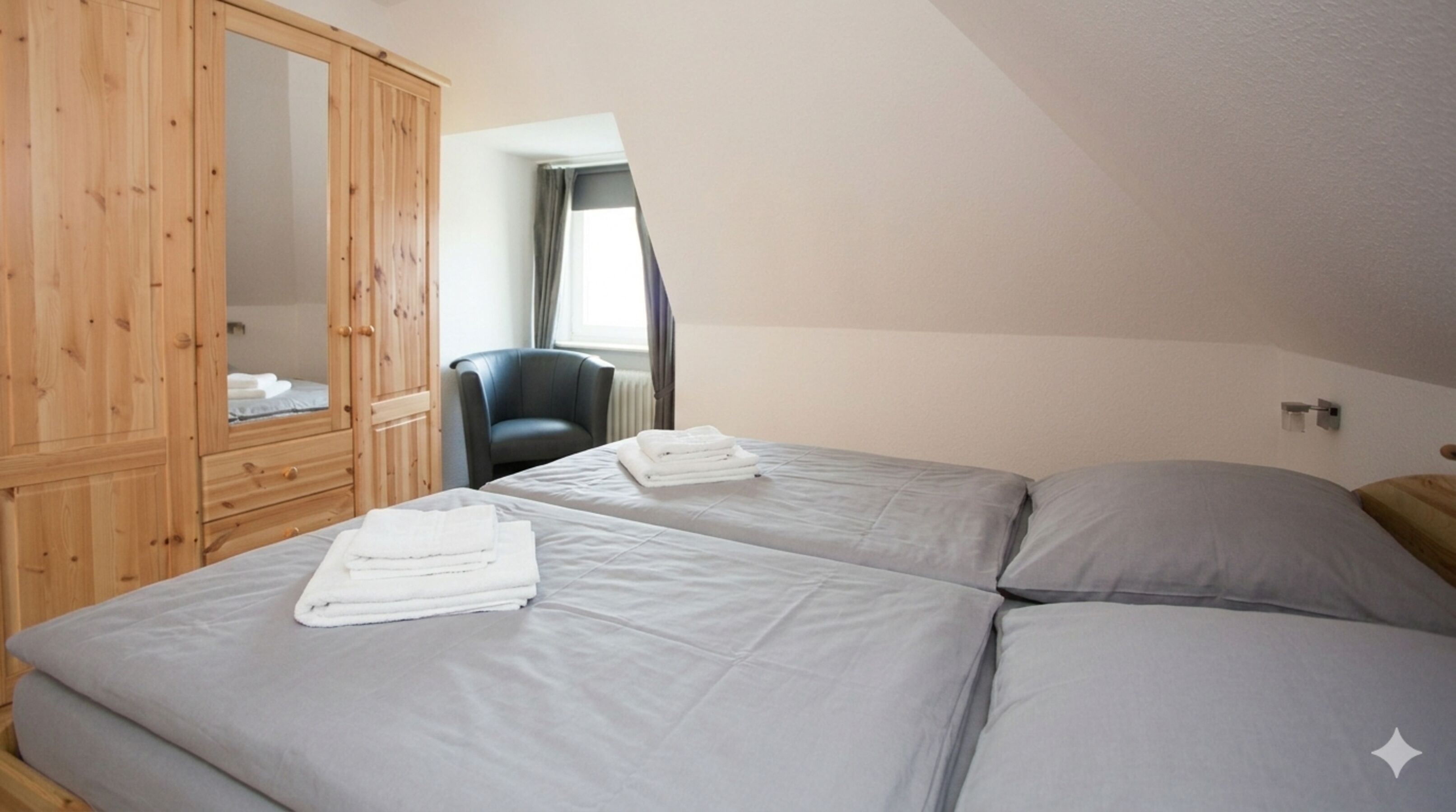 Schlafzimmer 1 - Doppelbett, Schrank und Sessel – euer Rückzugsort zum sanften Abschalten.