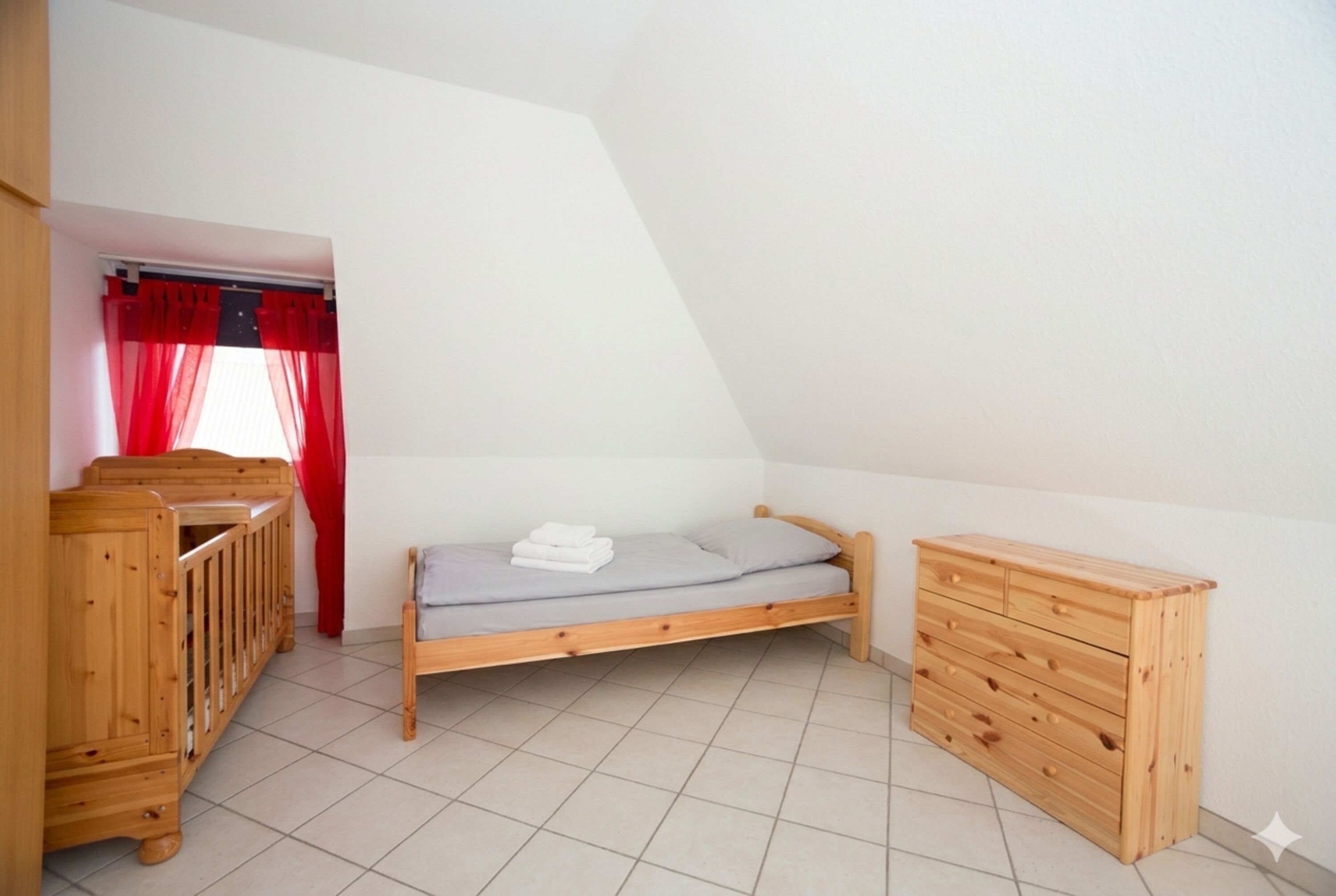 Schlafzimmer 2: kuscheliges Einzelbett und Kleinkinderbett – perfekt für die Großen und die ganz Kleinen.