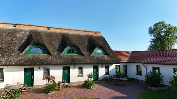 Terrasse vor den Wohnungen mit Reetdach