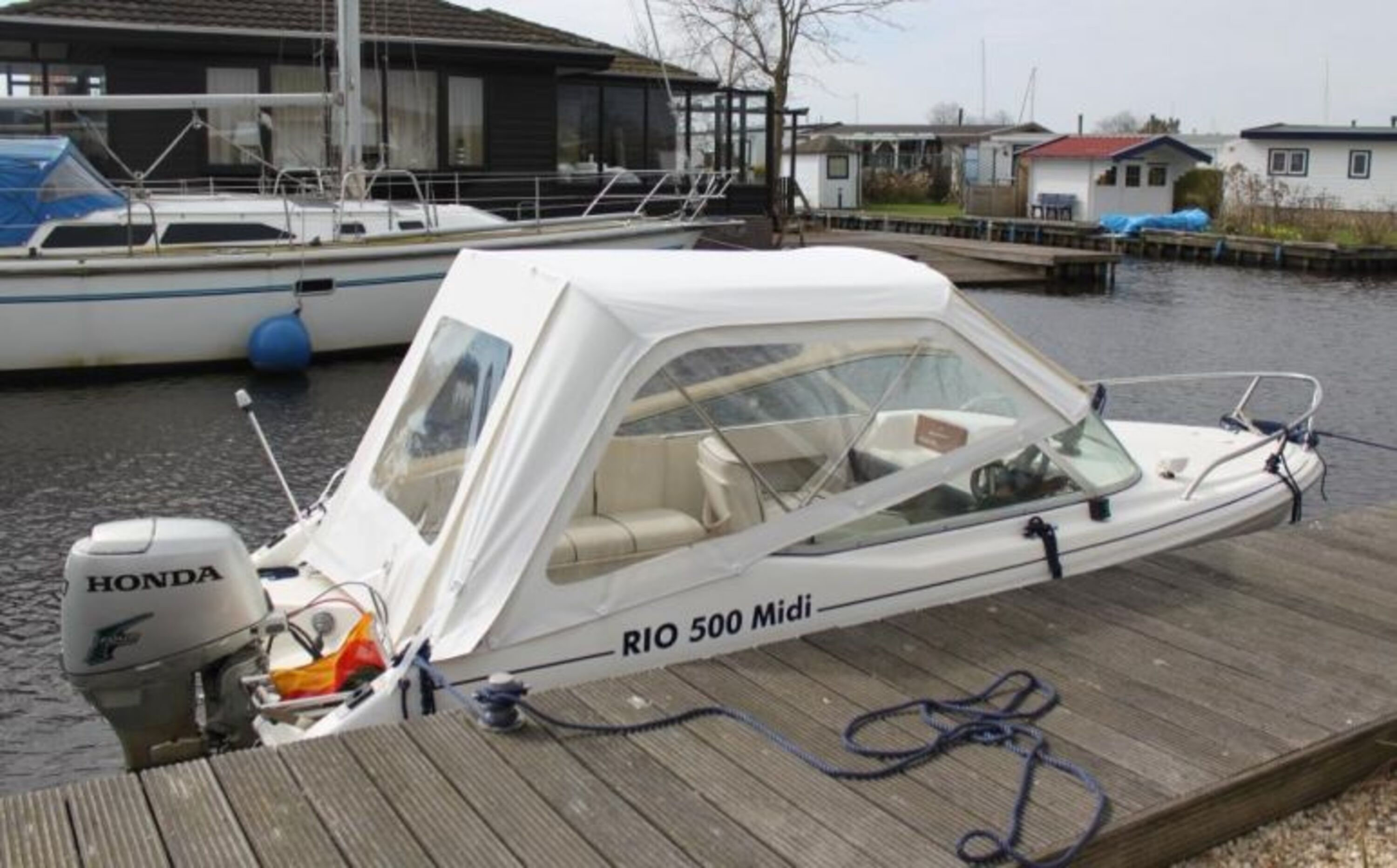 Blick durch das Esszimmerfenster auf das Sportboot Rio Midi, 40 PS