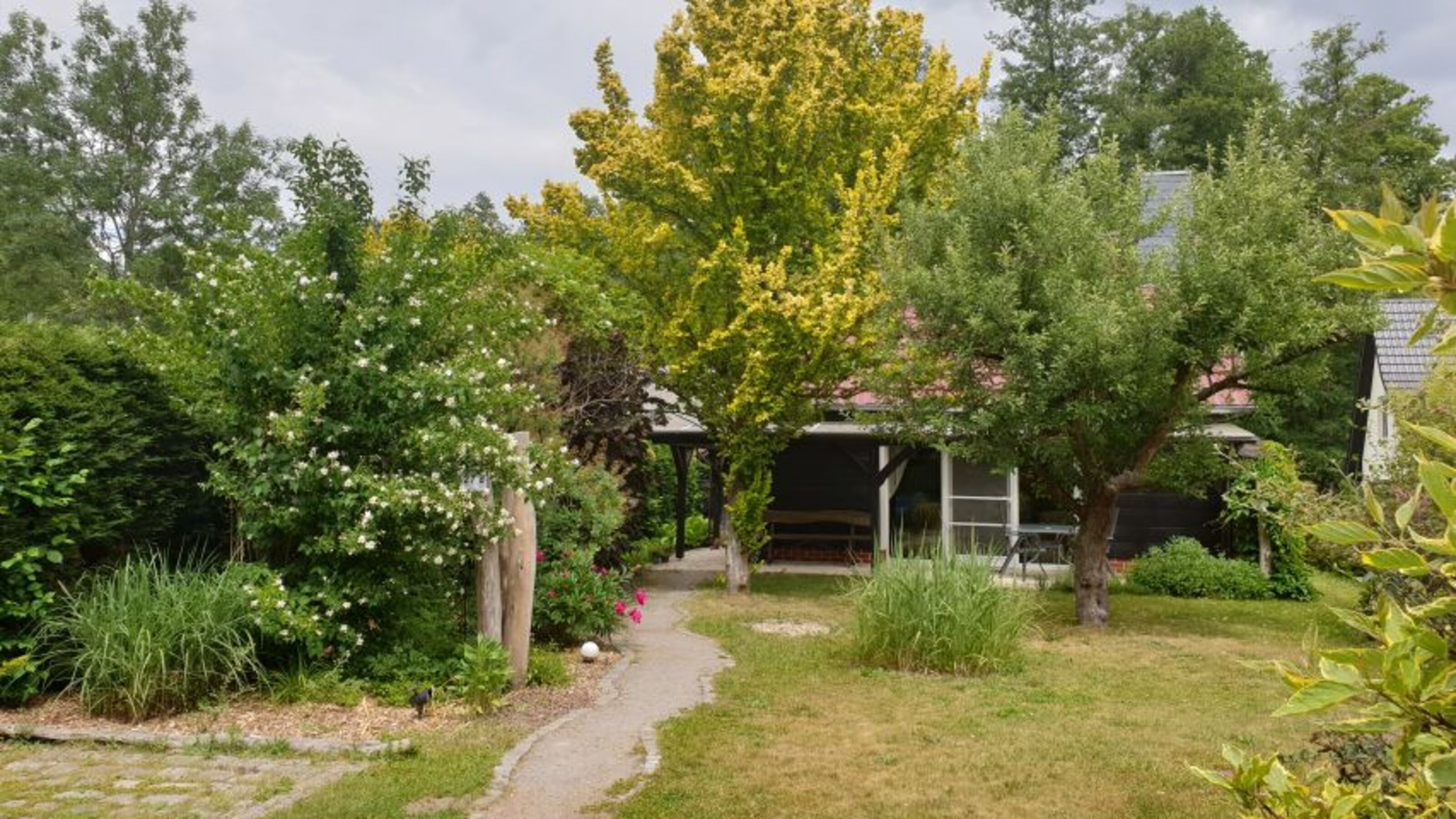 Ferienhaus mit überdachter Terrasse und Gartenbereich