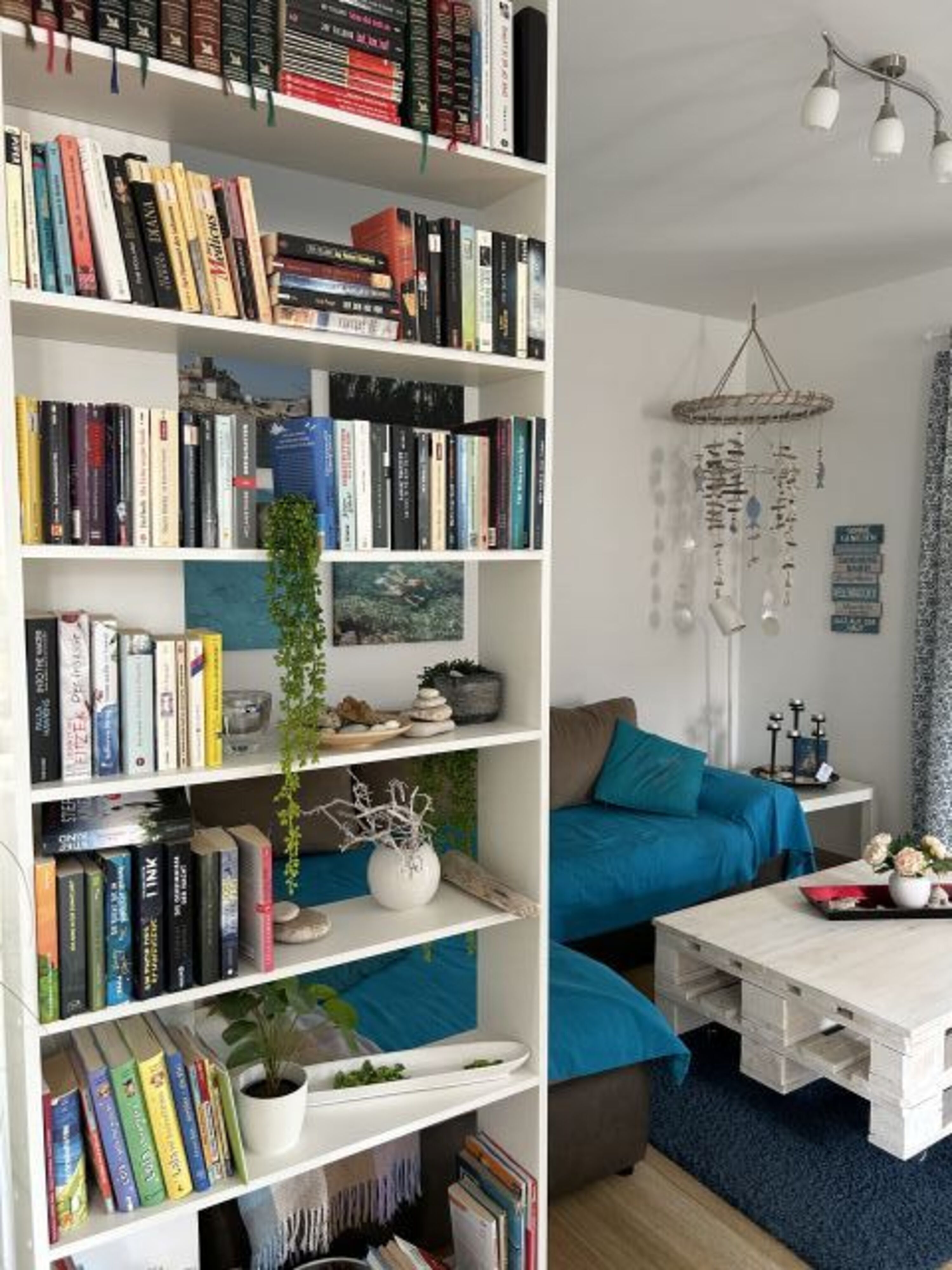 Blick in den Wohnraum mit Bücherauswahl & großer, gemütlicher Couch