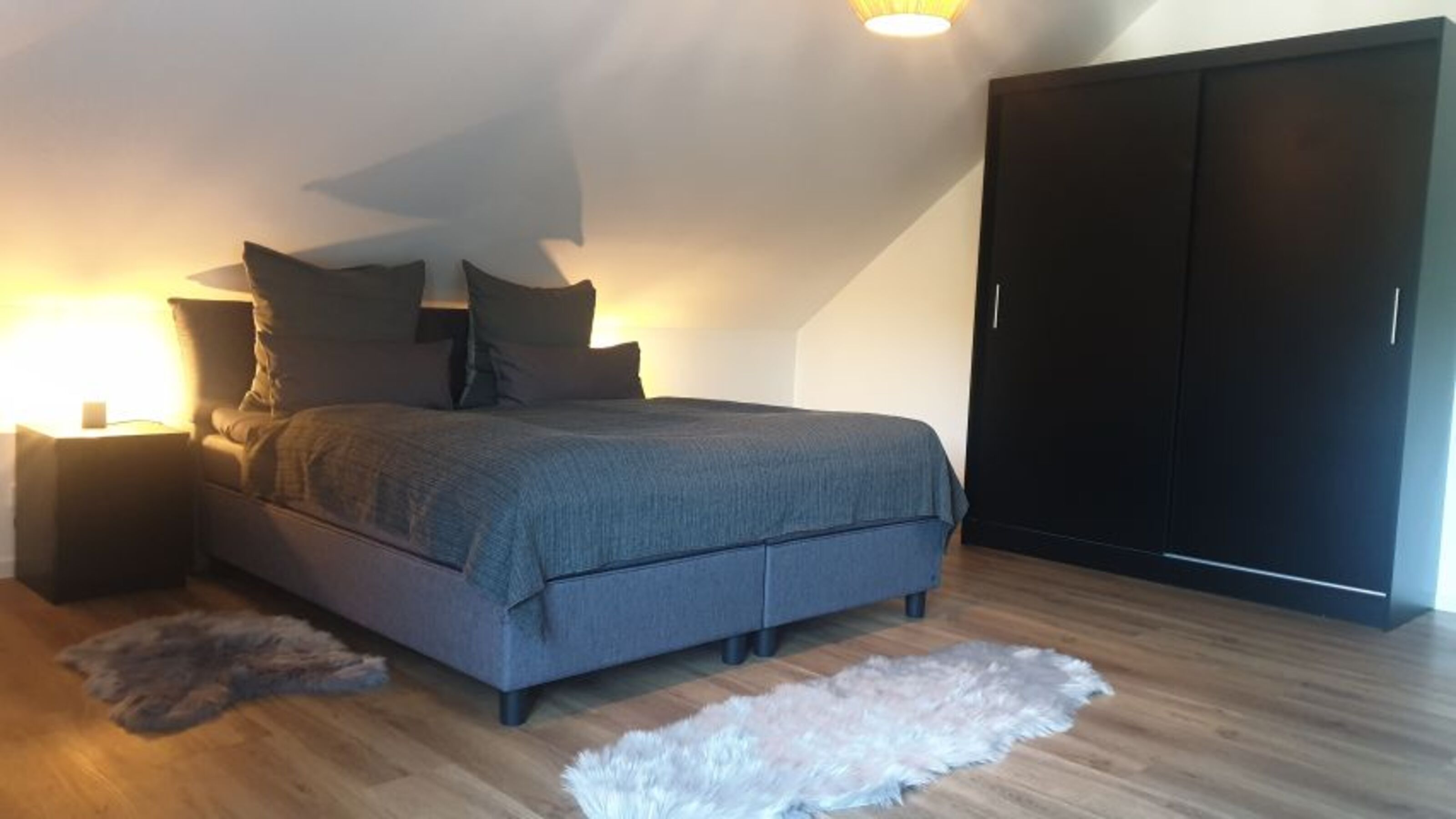 Großer Schlafraum mit Zugang zum Balkon und Sat-TV