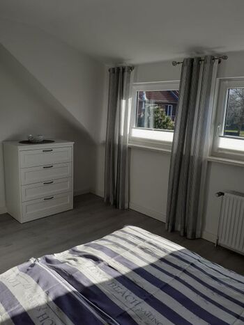 Schlafzimmer mit Kommode und Jalousien