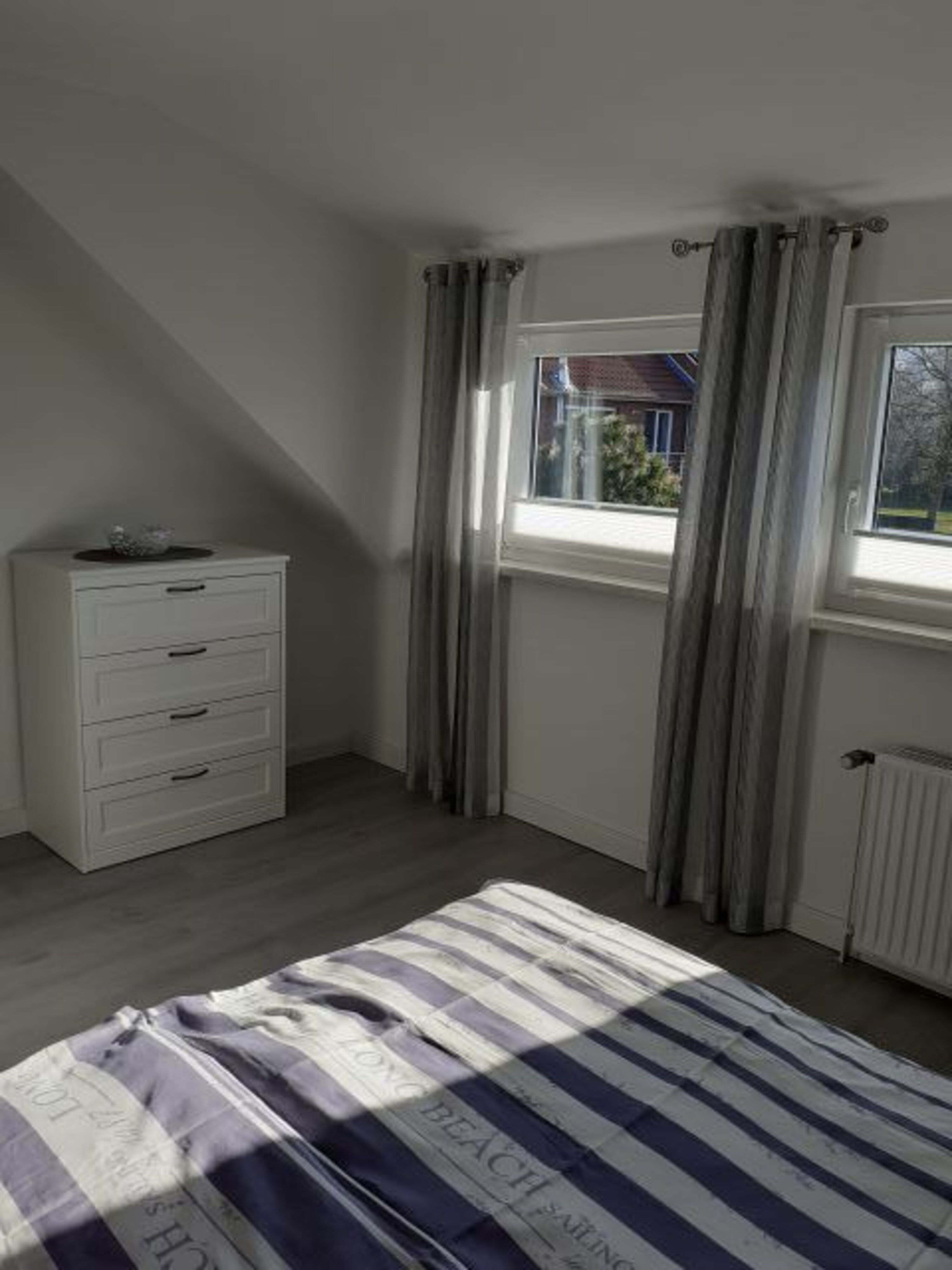 Schlafzimmer mit Kommode und Jalousien