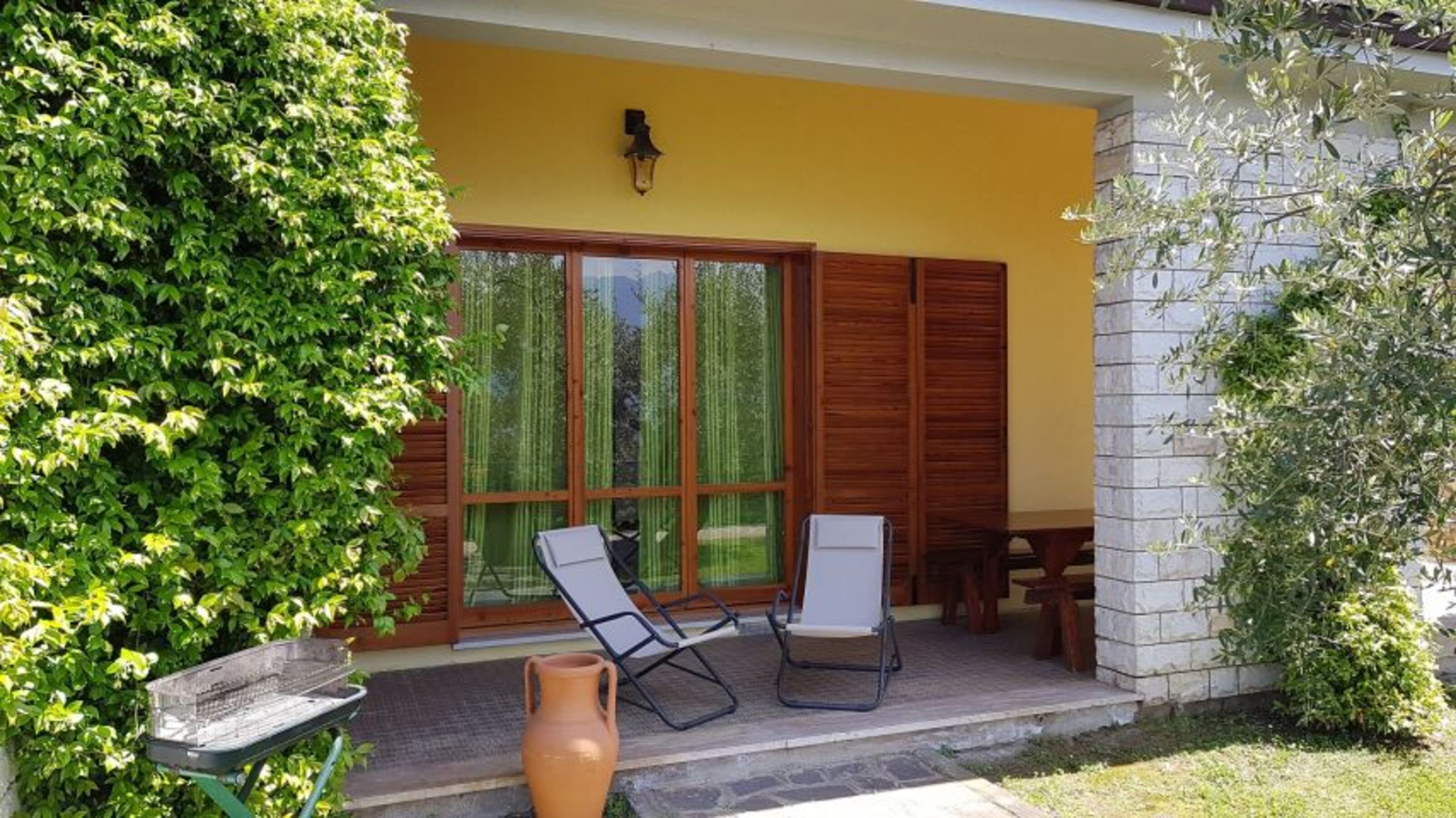 Terrasse mit Gartenmöbeln und Grill
