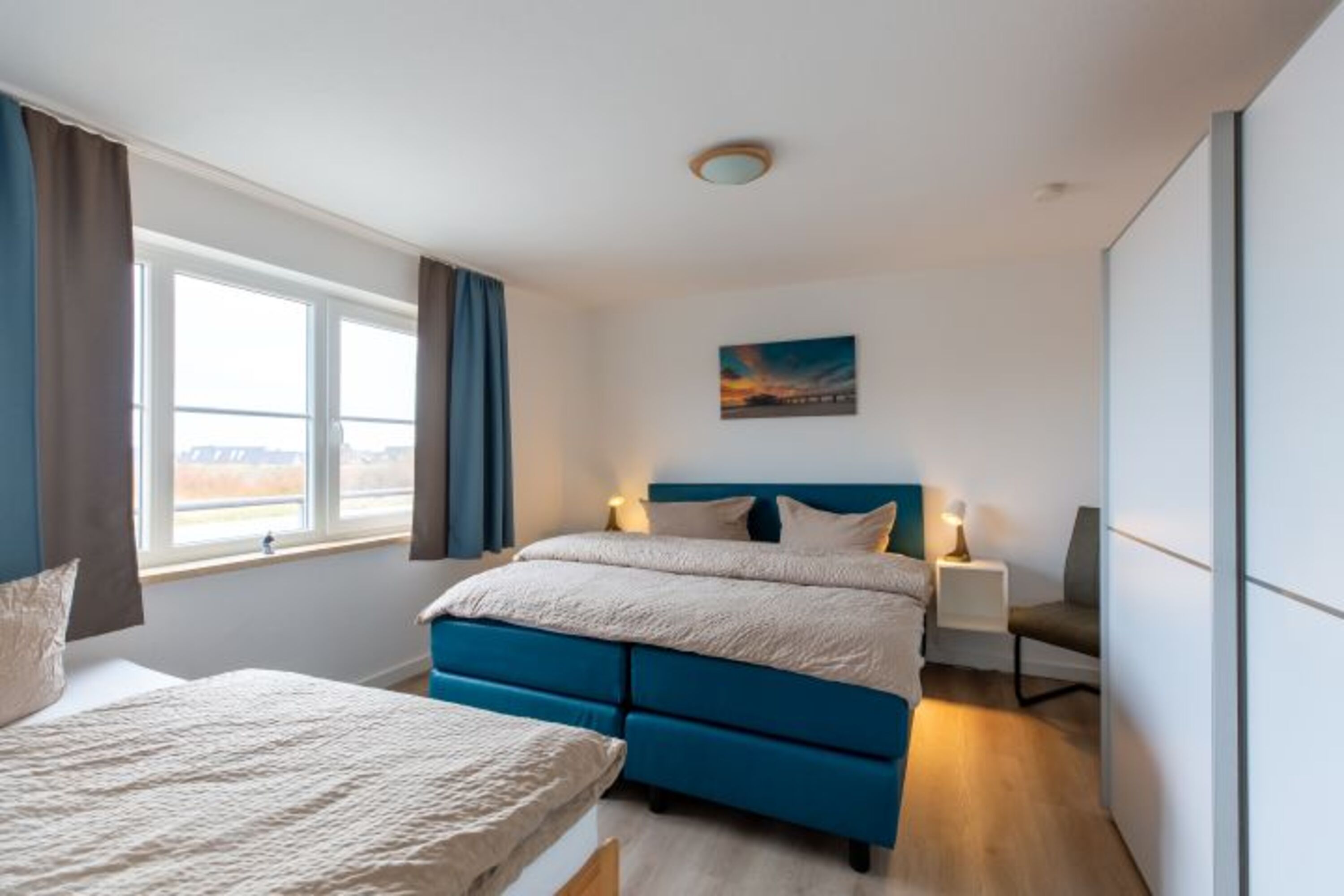 Schlafzimmer mit einem Boxspringdoppelbett und einem Einzelbett