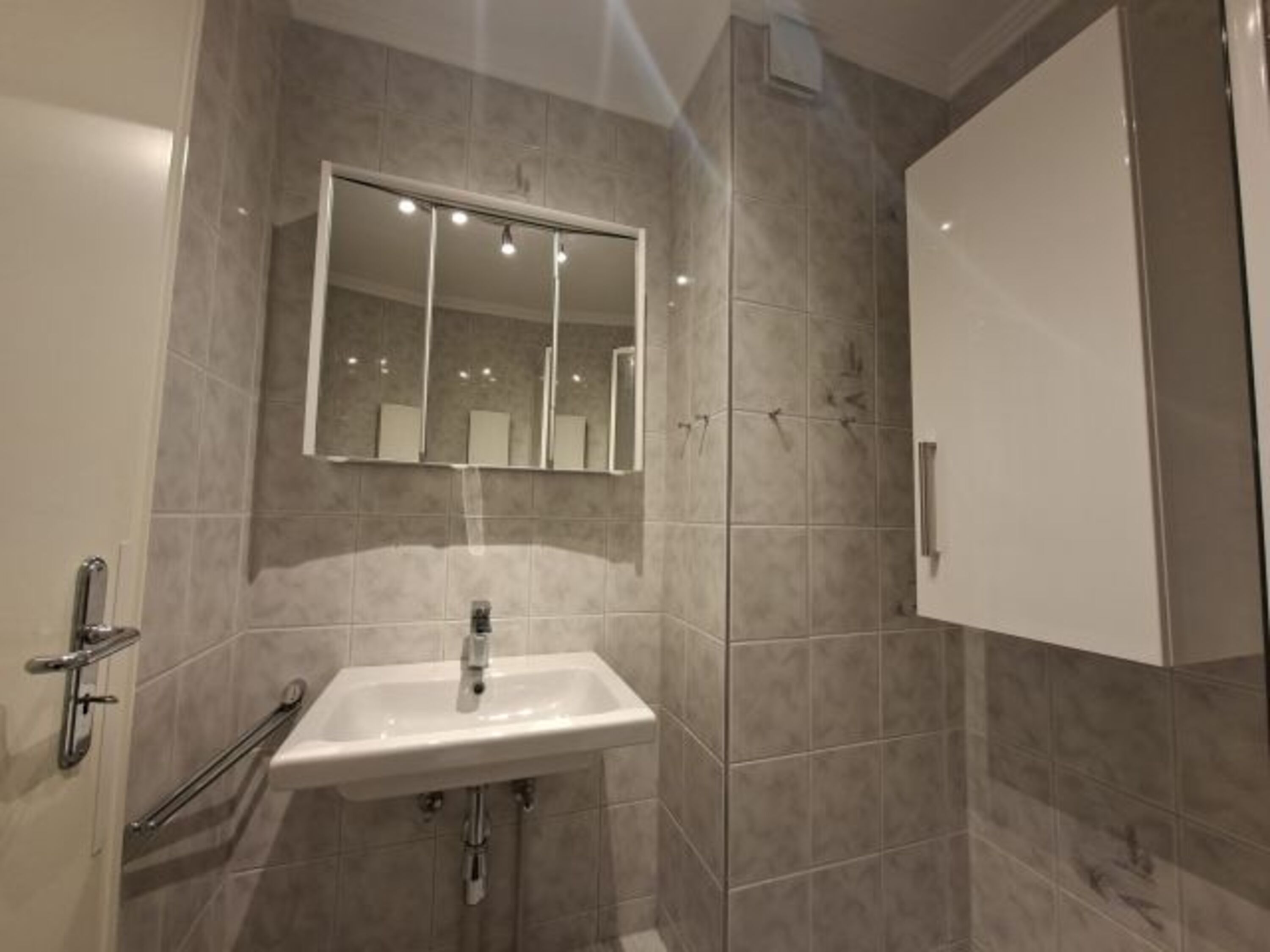 Bad mit Waschbecken, Spiegelschrank und Waschbecken