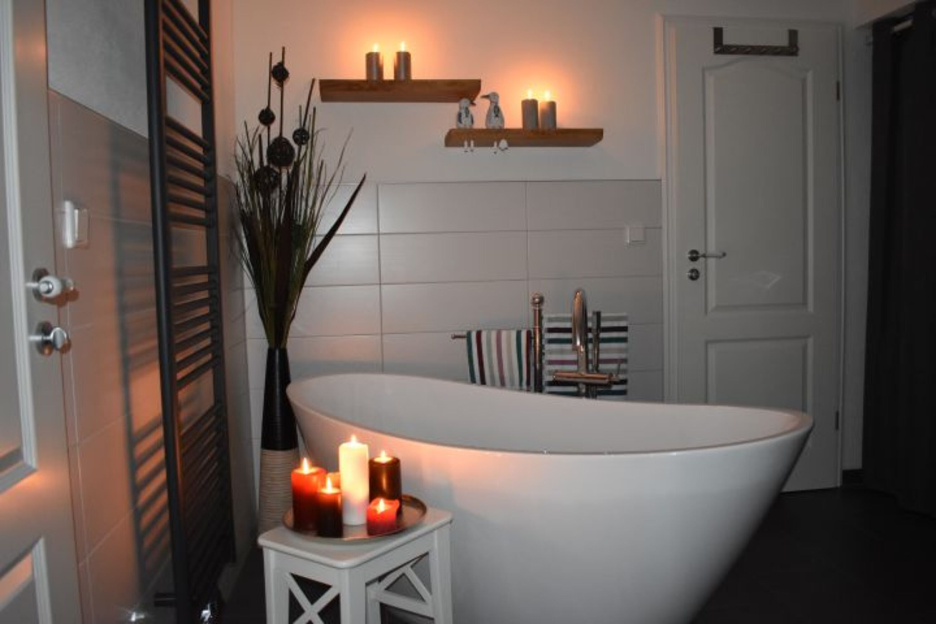 Ein Bad mit freistehender Badewanne und ebenerdiger Dusche wartet auf euch
